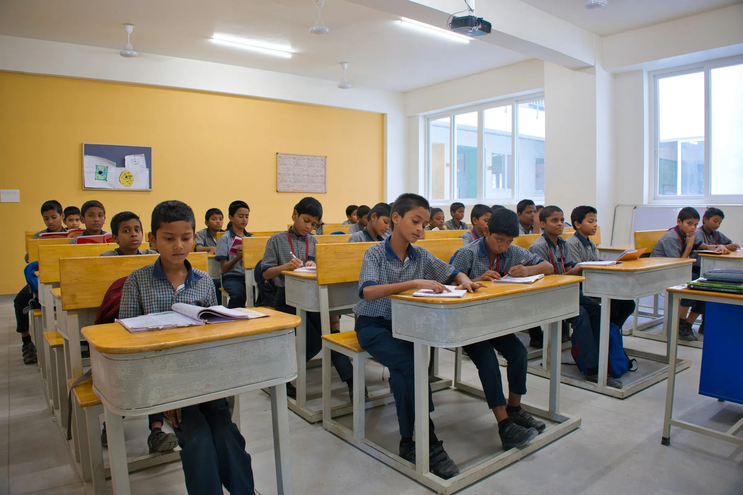 Students working at tables in a classroom, building and testing projects
